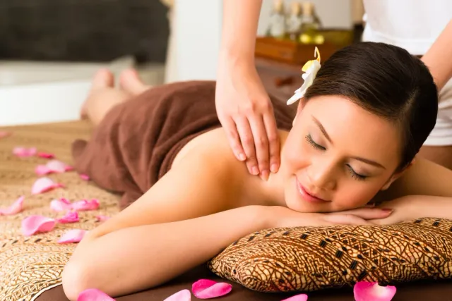 Masaż karku i ramion – masażystka wykonuje ucisk na górnej części pleców klientki w salonie Beauty Essence